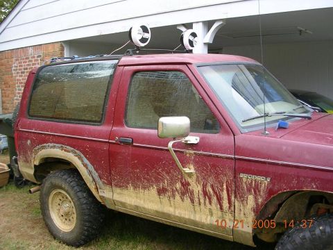 1989 Ford Bronco II - This 1989 Ford Bronco II is heavily covered in mud, suggesting recent off-road use.