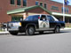1991 Ford LTD Crown Victoria - Tiny thumbnail-sized photo of a black-and-white police cruiser sedan with a roof lightbar and door shield, shot from a rear three-quarter a…