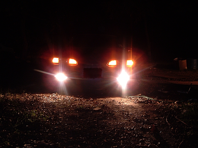 car headlights on at night, facing forward