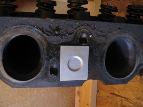 1979 Ford Bronco - Close-up of an engine cylinder head, showing valve springs and a metal plate covering a bolt hole. Text from Supermotors.net is visible.