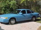 1994 Ford Crown Victoria - Side view of a light blue 1994 Ford Crown Victoria sedan parked on a paved surface.