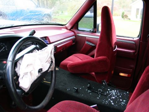 1994 Ford Bronco - The interior of the vehicle shows signs of a collision, including a deployed airbag and broken glass.