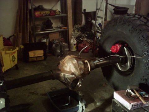 1986 Ford Bronco - The photo shows a vehicle's rear axle assembly and a large tire, likely in a garage or workshop setting.
