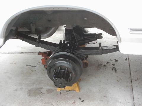 1978 Ford Bronco - Close-up view of the rear suspension and axle components of a vehicle undergoing maintenance.