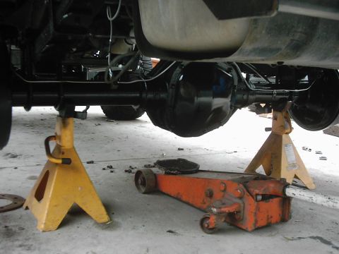 1978 Ford Bronco - Undercarriage view of a vehicle's rear axle and suspension system supported by jack stands.