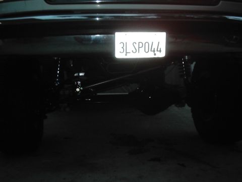 1978 Ford Bronco - The rear of a vehicle is visible, displaying a license plate and suspension parts.