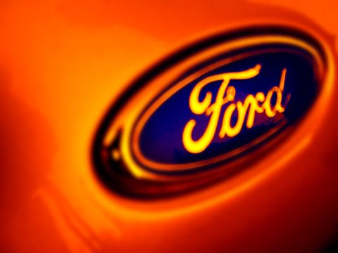 1967 Ford Ranchero - Illuminated Ford oval emblem on an orange surface.