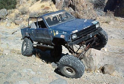 1986 Ford Bronco - This modified pickup truck is navigating a rocky, off-road course.