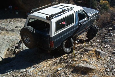 1986 Ford Bronco - This SUV navigates a challenging off-road path, demonstrating its capabilities.