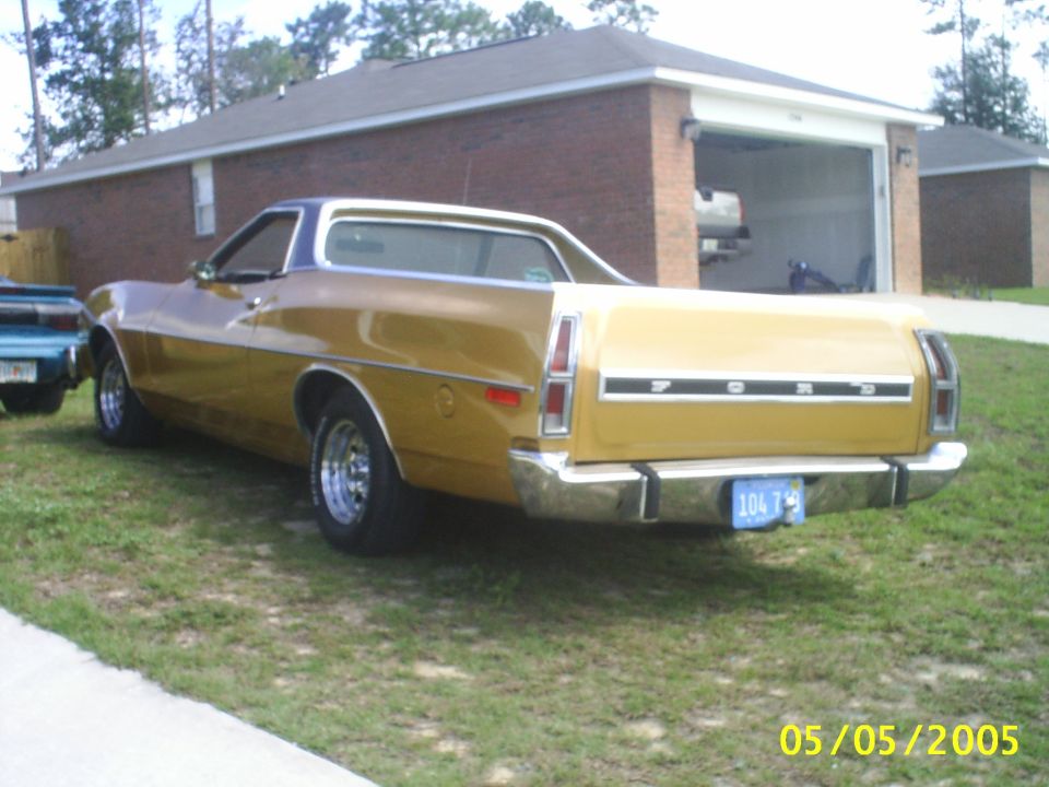 Gold Ford Ranchero coupe utility parked on grass, rear three-quarter view