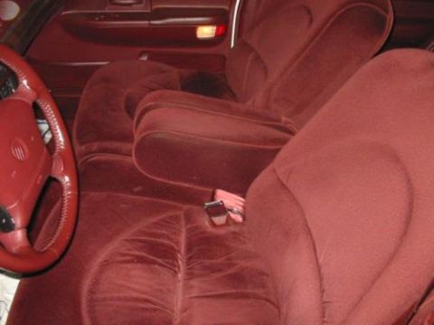 1996 Mercury Grand Marquis - Interior view of a 1996 Mercury Grand Marquis, plush red velvet upholstery and a prominent steering wheel.