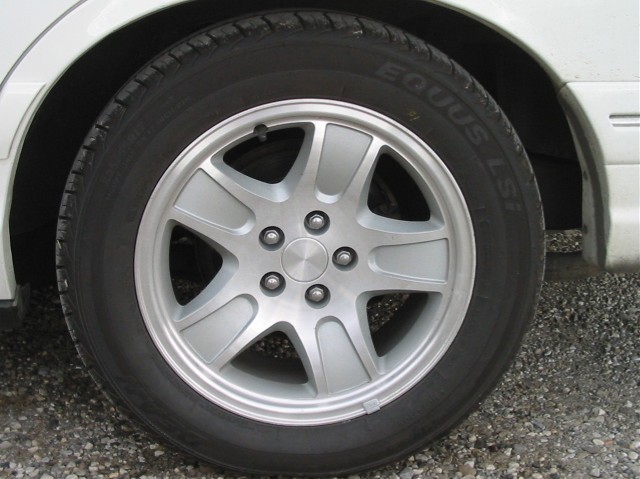 Silver alloy wheel with five spokes and a black tire