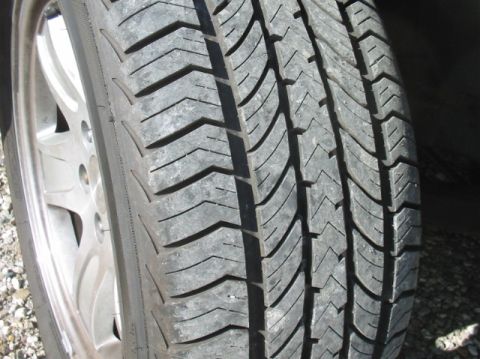 1996 Mercury Grand Marquis - Close-up view of a tire's tread pattern and a portion of the wheel.