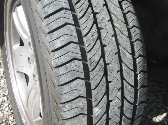 Close-up of a tire tread and part of a silver wheel