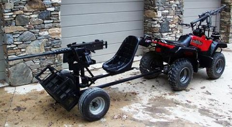 1998 Ford Crown Victoria - An all-terrain vehicle is outfitted with a heavy machine gun and a trailer, suggesting a custom or modified setup.