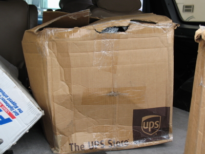 1999 Mitsubishi 3000GT - Several damaged cardboard boxes are visible inside a vehicle's cargo area.
