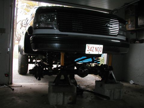 1994 Ford Bronco - Front view of a 1992 Ford Bronco undergoing suspension work in a garage.