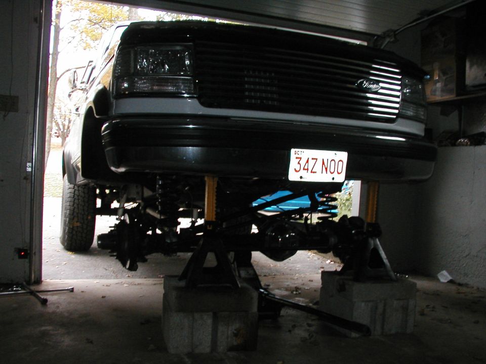 1992 Ford Bronco front end lifted on jack stands, showing suspension components