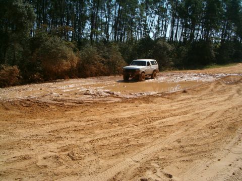 1991 Ford Bronco - A 1991 Ford Bronco navigates a challenging muddy off-road path.