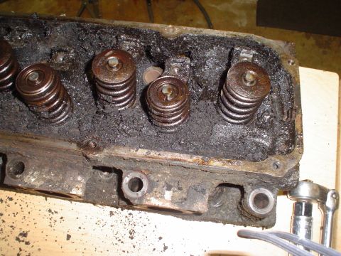 1981 Ford Bronco - This engine cylinder head is heavily coated in sludge, obscuring its details and making year identification impossible.