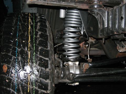 1994 Ford Bronco - Front suspension coil spring and tire detail.