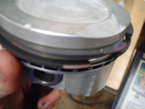 1981 Ford Bronco - A close-up view of a single engine piston, showing its internal structure and ring placement.