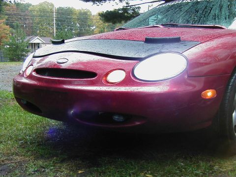 1997 Ford Taurus - Front view of a red 1996 Ford Taurus with a black car bra and visible headlights.