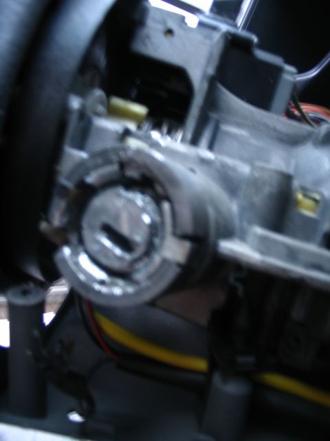 1993 Ford Taurus - Close-up of a vehicle's ignition cylinder and surrounding steering column components.