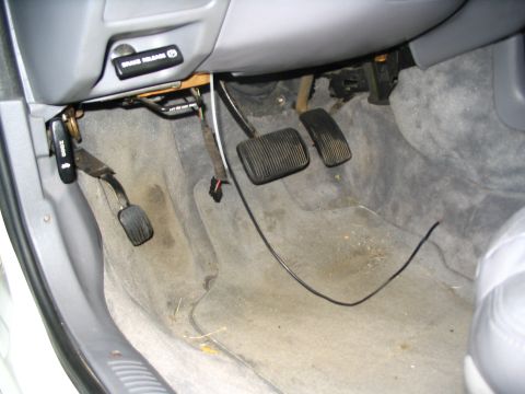 1993 Ford Taurus - The interior floor of a vehicle shows the brake and accelerator pedals, along with a brake release lever and keys.