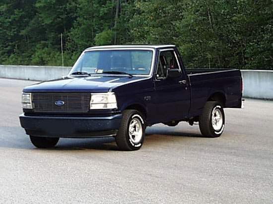 Dark blue 1992 Ford F-150 pickup truck, front 3/4 view, parked on asphalt