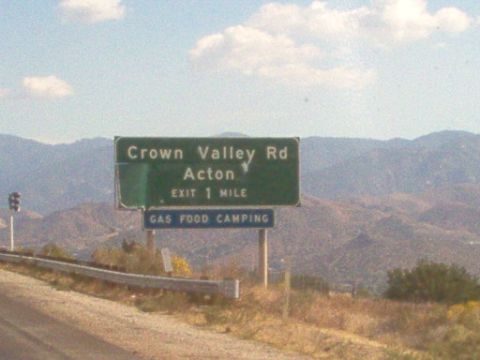 1988 Ford Bronco - A green highway sign indicates directions to Crown Valley Road and Acton, with an exit 1 mile away and services available.