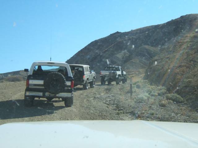 1988 Ford Bronco and two other SUVs on a dirt road
