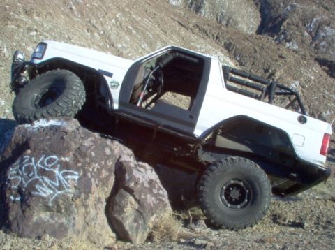 1988 Ford Bronco - Modified Jeep Cherokee XJ navigating a rocky incline off-road.
