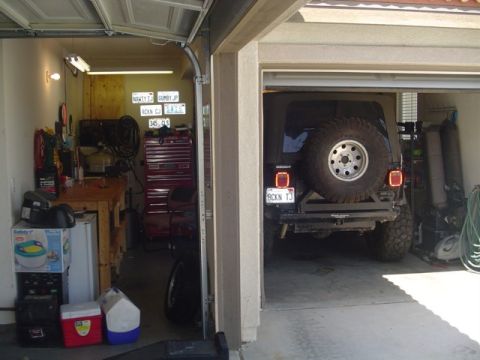 2000 Jeep TJ - Rear view of a Jeep TJ parked in a garage, a spare tire mounted on the back and a custom license plate.