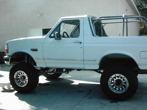 1978 Ford Bronco - This lifted white Ford Bronco features an aftermarket roll cage and custom wheels.