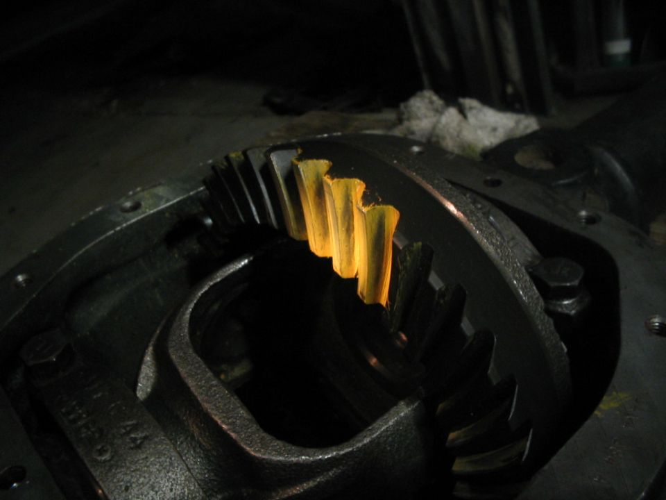 Pinion gear teeth lit yellow inside a dark differential housing