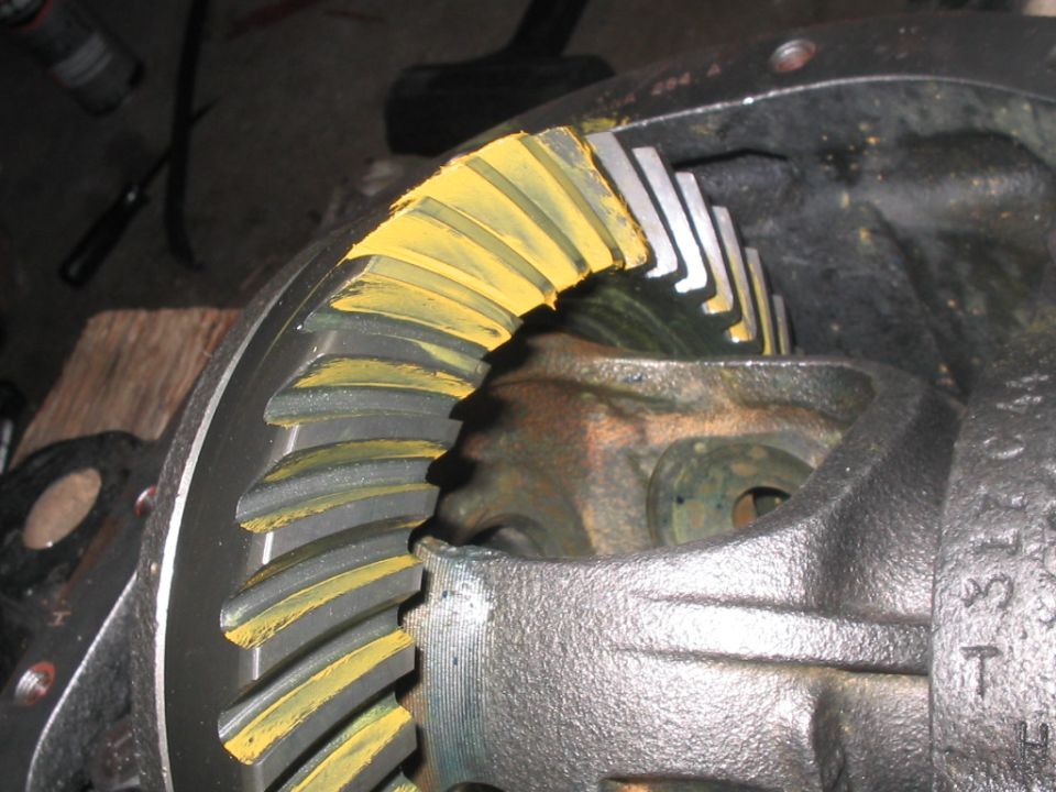 Close-up of differential ring gear teeth marked with yellow compound on a bench