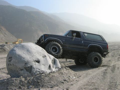 1985 Ford Bronco - This 1985 Ford Bronco navigates a challenging off-road obstacle, demonstrating its capabilities.