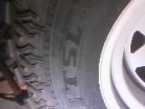 1986 Ford Bronco - A close-up view of a tire and wheel assembly, showing tread detail and rim.
