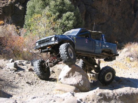 1986 Ford Bronco - Off-road truck navigating a boulder obstacle on a rocky trail.