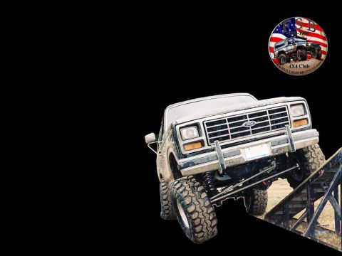 1986 Ford Bronco - This lifted Ford truck is shown on a ramp, with a 4x4 club sticker in the upper right corner.