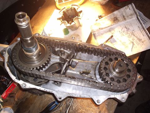 1985 Ford Bronco - A disassembled transfer case (Borg-Warner 1345/208-style) sits open on a workbench, exposing its drive chain, front and rear output sprocke…