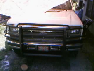 1986 Ford Bronco - This white Ford Bronco is equipped with a heavy-duty grille guard, and its front end is captured in this image.