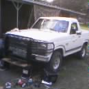 1986 Ford Bronco - This white pickup truck, likely a 1987 model, is shown from the front with a prominent grille guard.