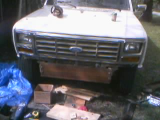 1986 Ford Bronco - Front view of a white Ford Bronco with a custom winch plate bumper, showing the grille and headlights.