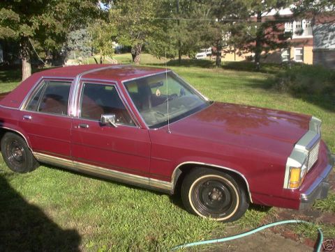 1991 Ford LTD Crown Victoria - This maroon sedan, seen from the front quarter angle, exhibits styling cues typical of late 1980s to early 1990s American sedans.