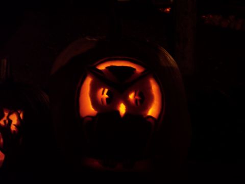 2001 Ford Crown Victoria - A carved pumpkin displays an owl face, lit from behind for Halloween.