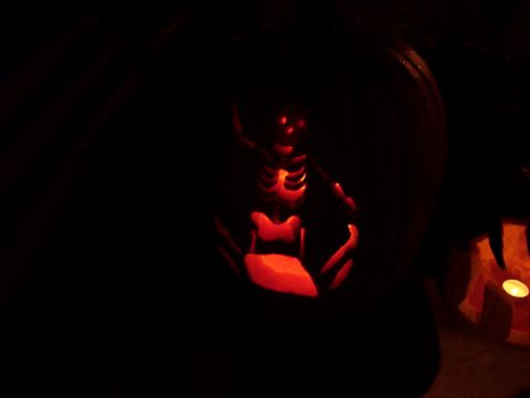 2001 Ford Crown Victoria - A carved pumpkin features a skeleton design, illuminated by an internal light source.