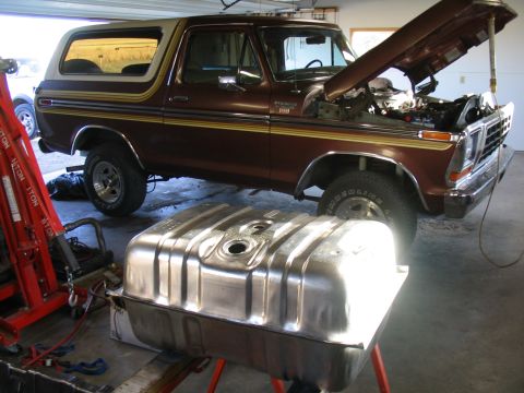 1979 Ford Bronco - A brown 1978 Ford Bronco is parked with its hood open, and a fuel tank sits in front of it.