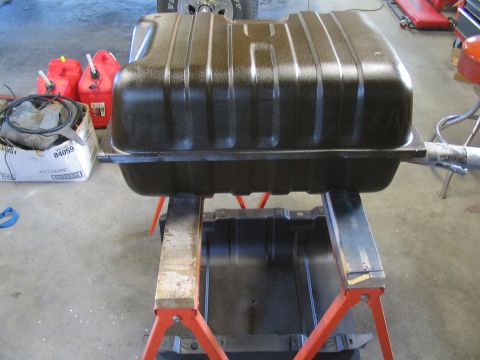 1979 Ford Bronco - A brown fuel tank is shown on jack stands, with red gas cans visible in the background.
